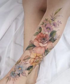 a woman's foot with flowers and leaves on it