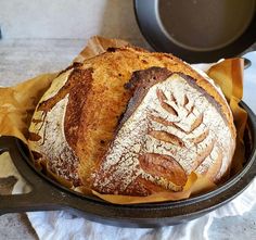 a loaf of bread sitting in a skillet on top of a white table cloth