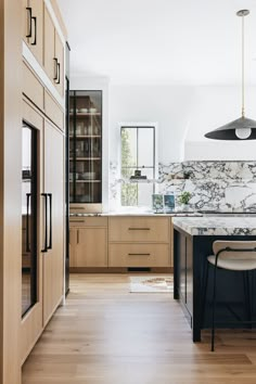 a kitchen with wooden cabinets and marble counter tops