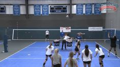 some people are playing tennis on a blue and gray court with white signs in the background