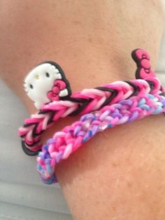 the hello kitty bracelet is decorated with pink, purple and blue braided rubber beads