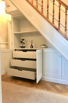 an under the stairs storage area with drawers