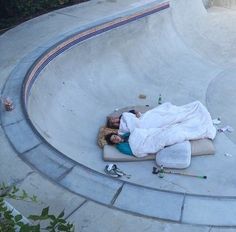 a person sleeping on a mattress in a skate park