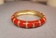 Red & gold, snaky patterned enamel paint, alloy metal slip-on bangle bracelet. Silver colored inside of band. Red Enamel Bangle Jewelry, Red Enamel Bangle Bracelets, Red Enamel Bangle Bracelet, Red Enamel Bangle, Red Metal Bangle For Party, Handmade Red Enamel Bracelets, Red Round Metal Bangle, Vintage Red Metal Bangle, Serpent Bracelet