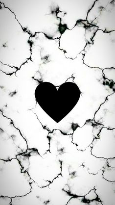 a black heart sitting on top of a marble floor