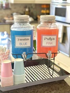 there are three jars with pink and blue drinks in them