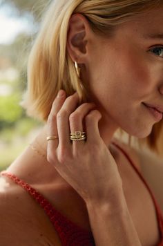 a woman with blonde hair wearing a red dress and gold ring on her left hand