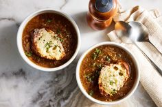 two white bowls filled with soup on top of a table