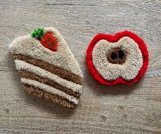 two small pieces of felt sitting on top of a wooden table next to each other