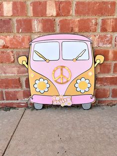 a pink and yellow vw bus with peace sign painted on it