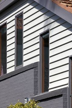 two windows on the side of a house