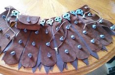 a wooden table topped with lots of brown leather pieces