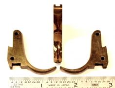 two pieces of metal are shown next to a ruler