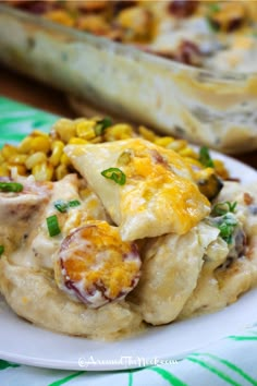 a close up of a plate of food with chicken and corn on it next to a casserole dish