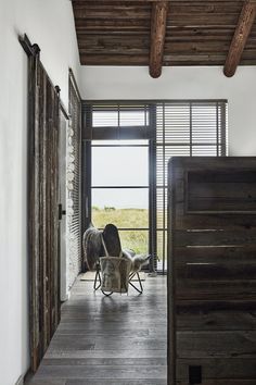 a rocking horse is sitting on the floor in front of an open door with shutters