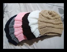 five knitted hats laying on top of each other