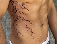 a man with no shirt has a lightning bolt tattoo on his stomach