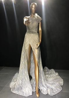 a mannequin dressed in silver and white with lights on the sides behind it