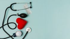 a stethoscope, blood pressure meter and red pillow on a blue background