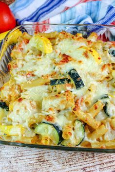 a casserole dish with zucchini, cheese and other vegetables in it