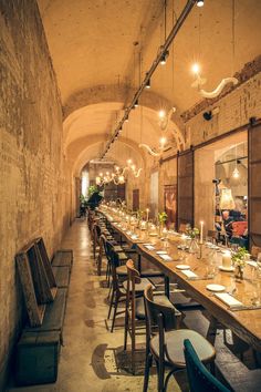 the long table is set up with place settings for people to sit down and eat