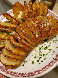 a white plate topped with sliced potatoes and parmesan sprinkled on top