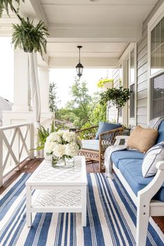 an instagram page with blue and white furniture on the front porch, along with flowers in vases