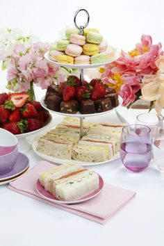 a table topped with cakes and desserts next to flowers