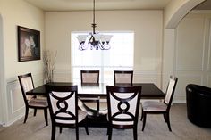 a dinning room table with chairs and a chandelier