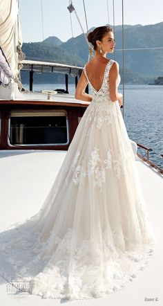 a woman in a wedding dress standing on the deck of a boat looking at the water