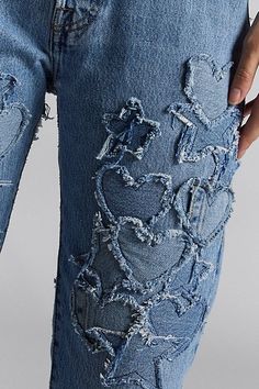 a person wearing ripped jeans with holes in the side and one hand on their hip