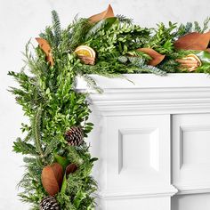 a christmas wreath with pine cones and oranges