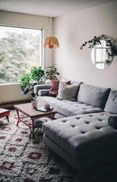 a living room filled with furniture next to a large window and a rug on the floor