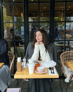 a woman sitting at a table with food in front of her