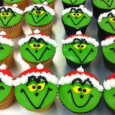 cupcakes with green frosting decorated as the grin face and santa's hat