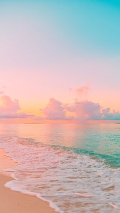 an ocean beach with waves coming in to shore and the sun setting on the horizon