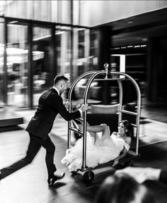 a man pushing a cart with a woman on it