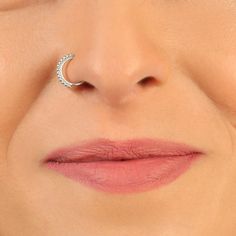 a woman's nose with a gold nose ring on top of her lip,