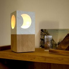 a wooden table with a lamp on top of it next to a book and other items