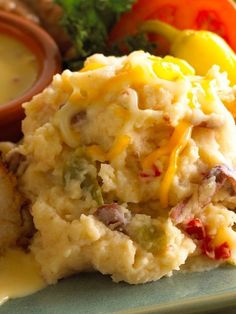 mashed potatoes with cheese and vegetables on a plate