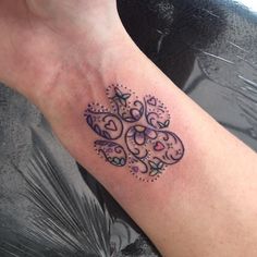 a small tattoo on the arm of a woman's left hand, with an intricate design