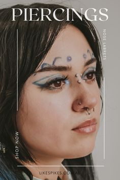 a woman with blue makeup and piercings on her face