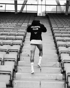 a man is walking up some steps in a stadium with his hoodie saying training club