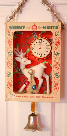 a clock hanging from the side of a wall with a reindeer decoration on it's face