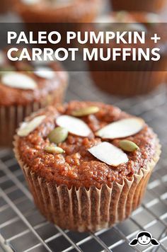 two muffins sitting on top of a cooling rack covered in frosting and nuts