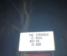 a sign that says the struggle is real but so is god on it at night