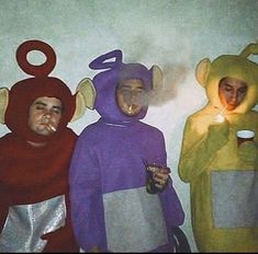 three people in animal costumes are standing next to each other and one is holding a lit candle