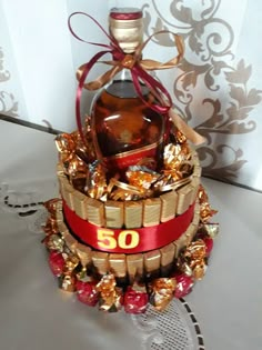 a bottle of wine sitting in a basket with candy and candies around it on a table