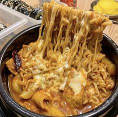 a bowl filled with noodles and sauce on top of a table