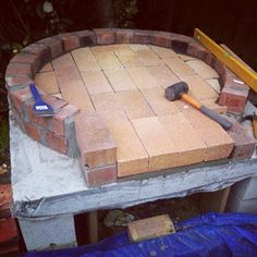 a brick fire pit being built with tools